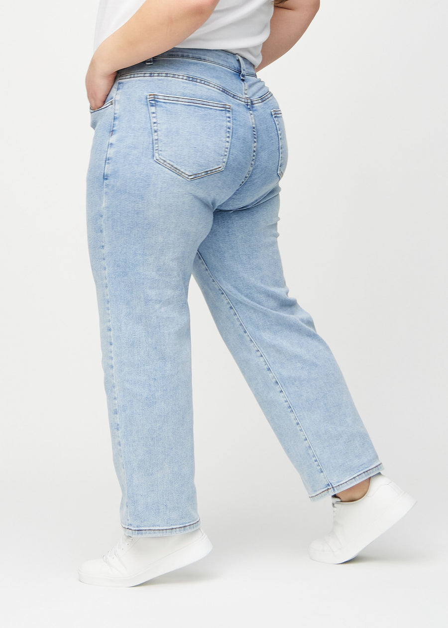 Loose jeans for women in light blue, color Waves. Side view on a plus-size model, showing the loose fit.