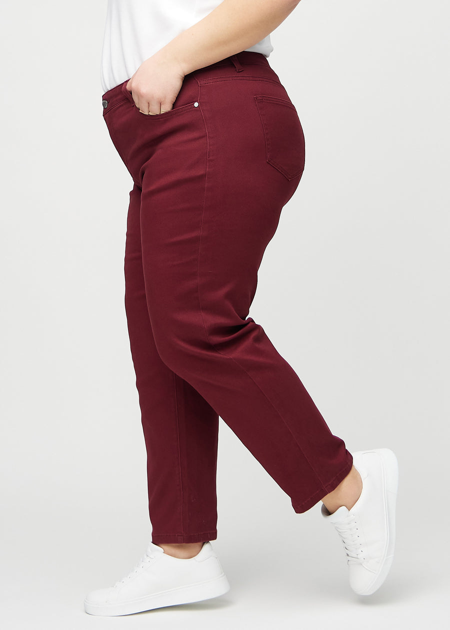Regular jeans for women in dark red, color Santas. Side view on a plus-size model.