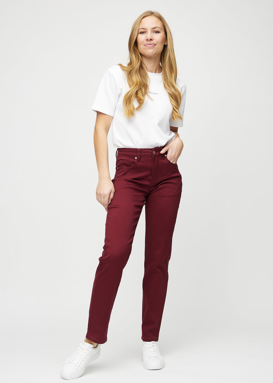 Regular jeans for women in dark red, color Santas. Full-length view of a model wearing the jeans.