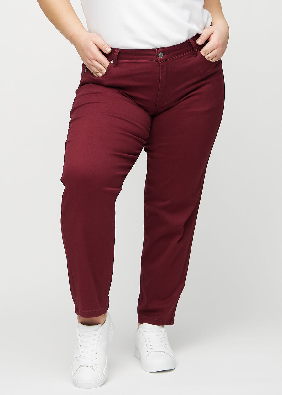 Regular jeans for women in dark red, color Santas. Front view on a plus-size model, showing the classic straight-leg fit.