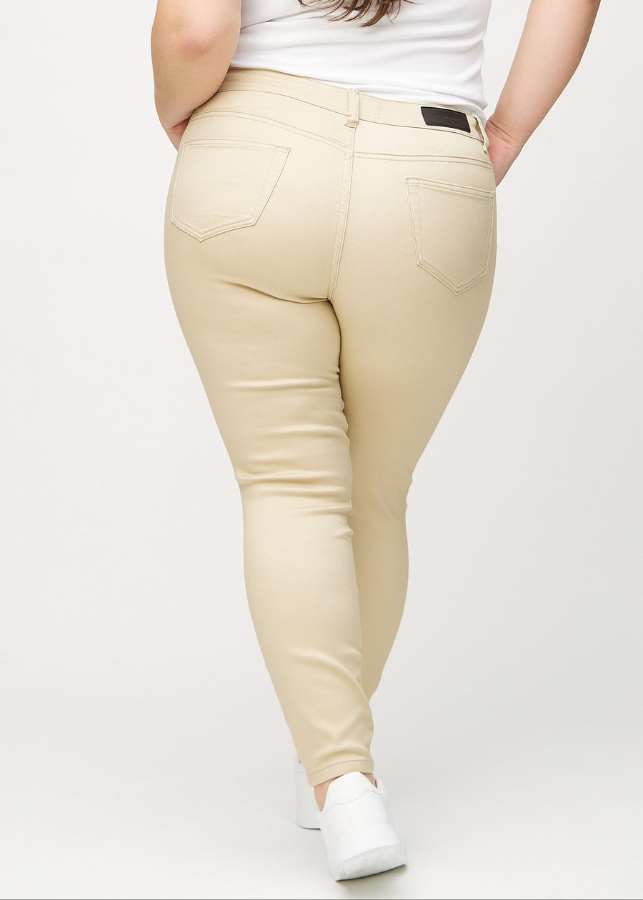 Beige skinny jeans seen from the back on a plus-size model, so the full product can be seen.