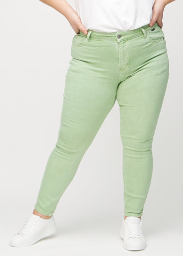 Skinny jeans for women in light green, color Mints. Front view on a plus-size model, showing the close fit through the legs.