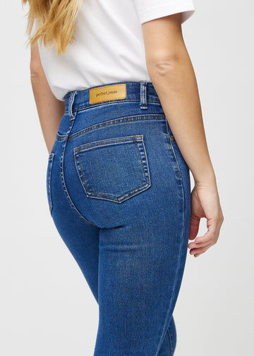 Skinny jeans for women in dark blue, color Oceans. Close-up back view on a model, showing details.