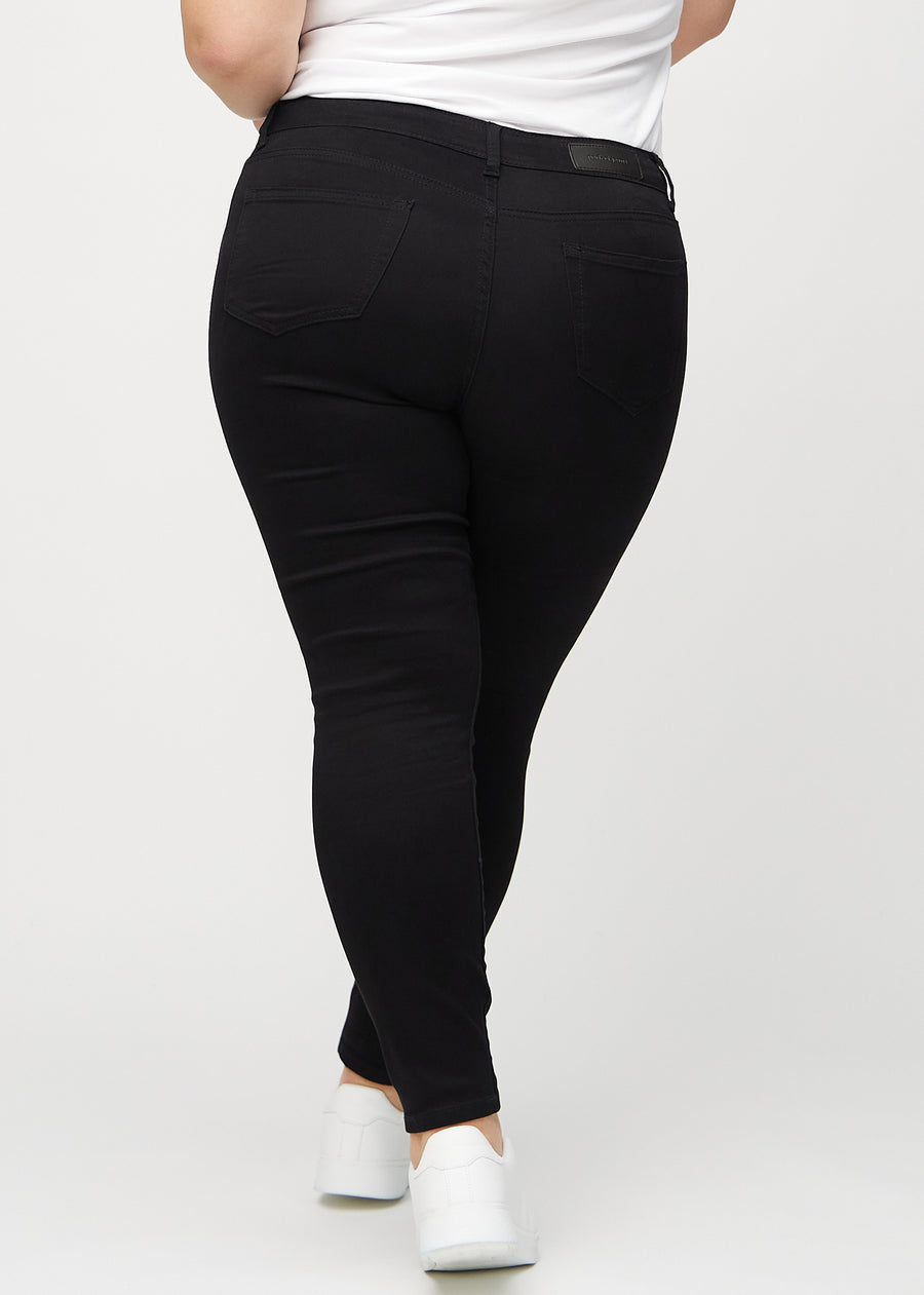 Black skinny jeans seen from the back on a plus-size model, so the full product can be seen.