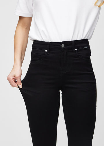 The model stretches the jeans at the thigh to show the stretch.