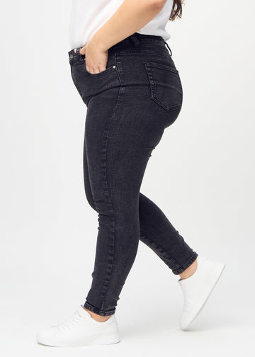 Skinny jeans for women in dark grey, color Shadows. Side view on a plus-size model.