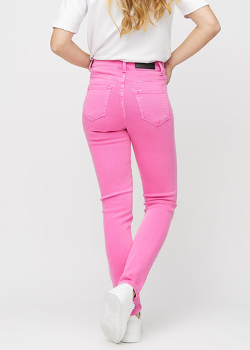 Slim jeans for women in light pink, color Flamingos. Back view on a model, showing the overall fit.