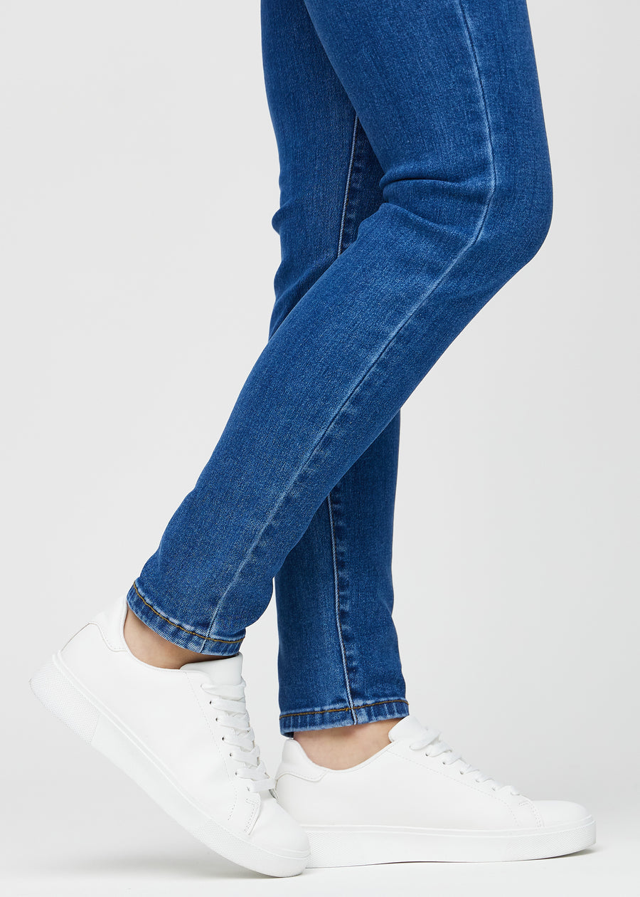 Slim jeans for women in dark blue, color Oceans. Close-up at the ankles on a model, showing the fit at the leg openings.