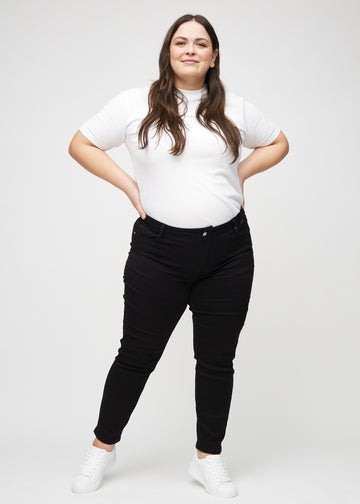 Full image of a plus-size model in black slim jeans.