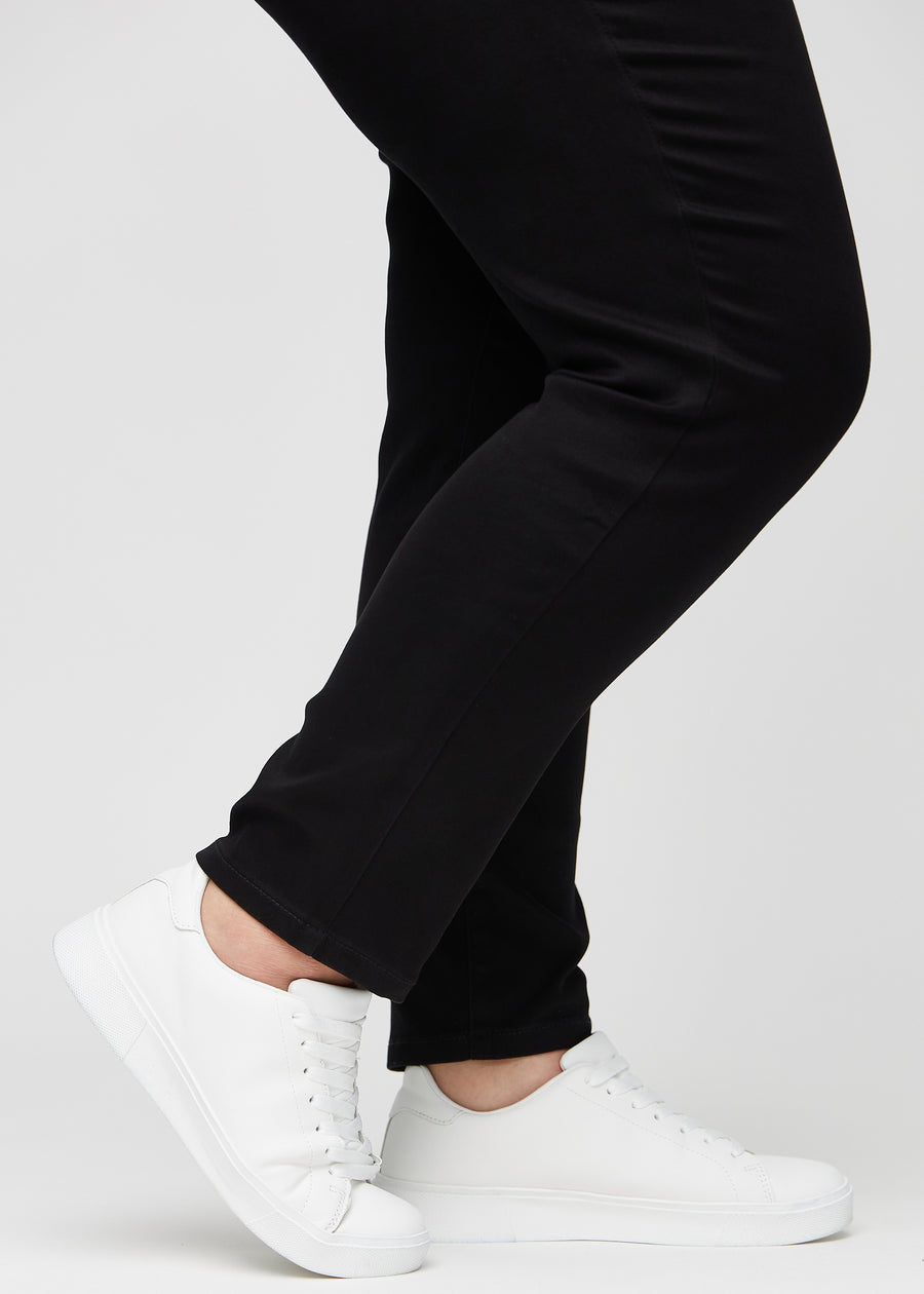 The ankles of a plus-size model, so you can see how closely the jeans fit in a Slim fit.