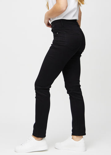Black slim jeans seen from the side on a model.