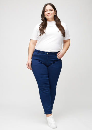 Slim jeans for women in dark blue, color Royals. Full-length view of a plus-size model wearing the jeans.