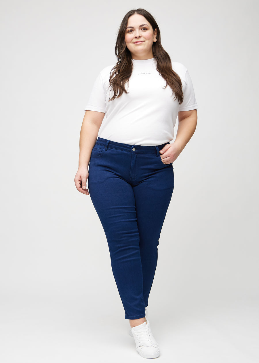 Slim jeans for women in dark blue, color Royals. Full-length view of a plus-size model wearing the jeans.