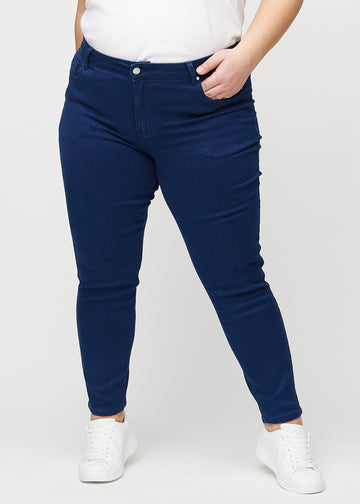 Slim jeans for women in dark blue, color Royals. Front view on a plus-size model, showing a close fit through the leg with a little more room at the ankle.