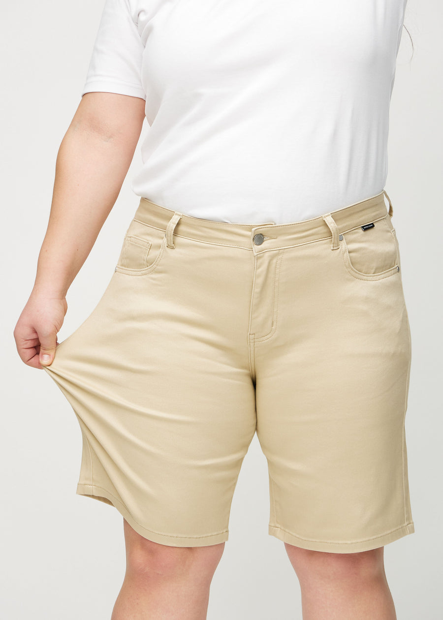 The plus-size model stretches the shorts at the thigh to show the stretch.