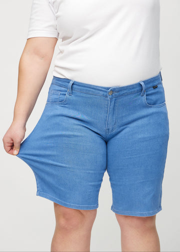 The plus-size model stretches the shorts at the thigh to show the stretch.