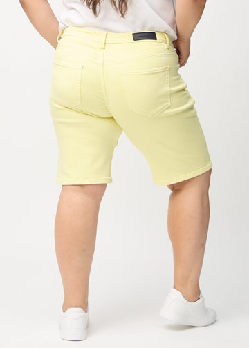 Light yellow regular middle shorts seen from the back on a plus-size model, so the entire product can be seen.