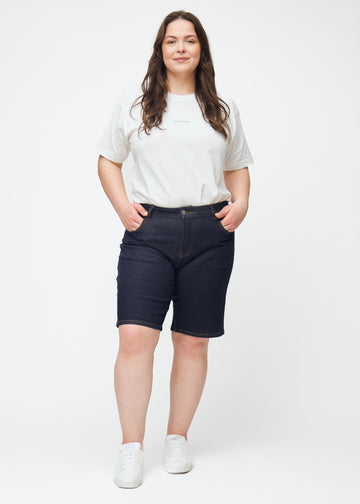 Full image of a plus-size model wearing deep dark blue denim shorts for women in the colour Midnights with a regular fit.