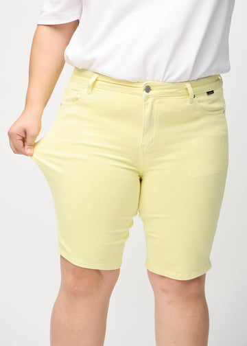 The plus-size model stretches the shorts at the thigh to show the stretch.