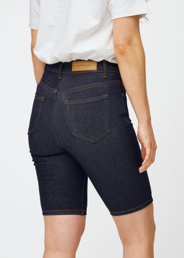 Deep dark blue denim shorts for women in the colour Midnights seen from the back in close-up to show fit and details.