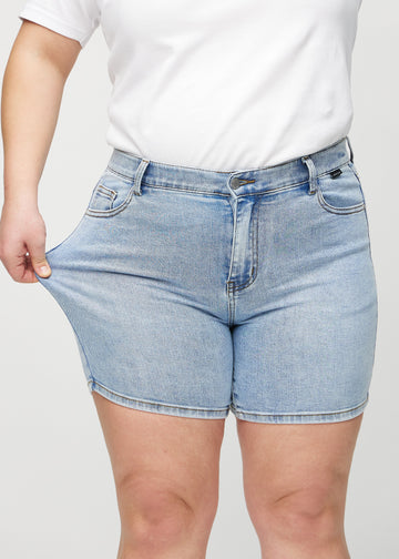 The plus-size model stretches the shorts at the thigh to show the stretch.
