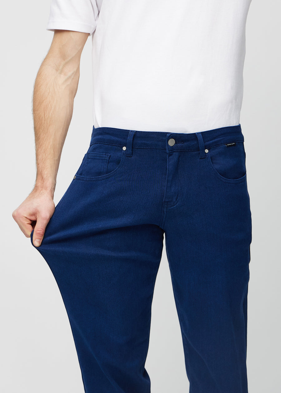 The model stretches the jeans at the thigh to show the stretch.