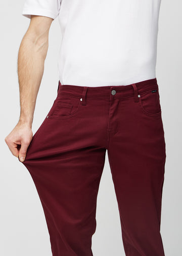 The model stretches the jeans at the thigh to show the stretch.