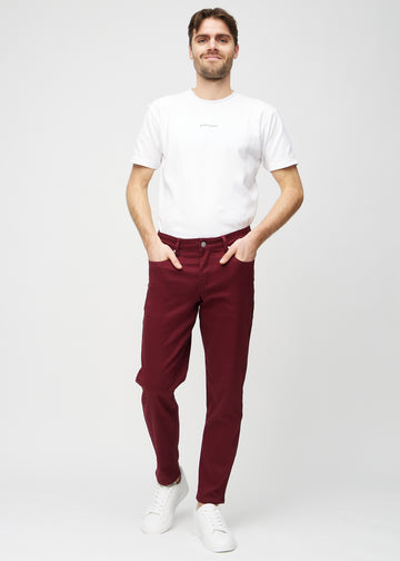 Full image of a model in dark red regular jeans.