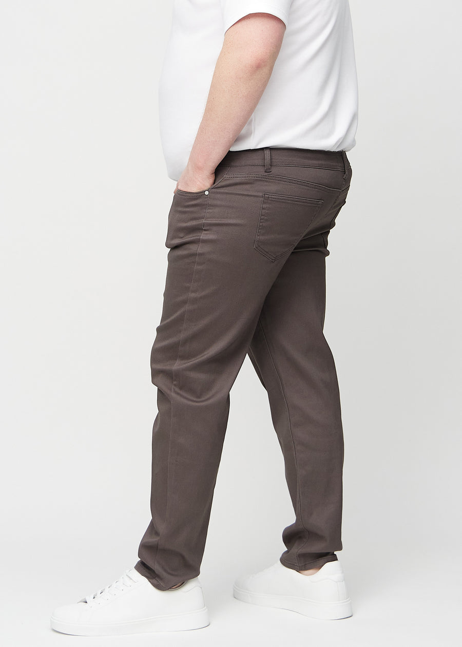 Grey-brown regular jeans seen from the side on a plus-size model.
