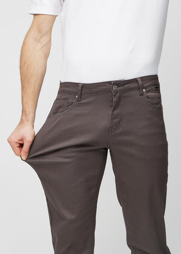 The model stretches the jeans at the thigh to show the stretch.