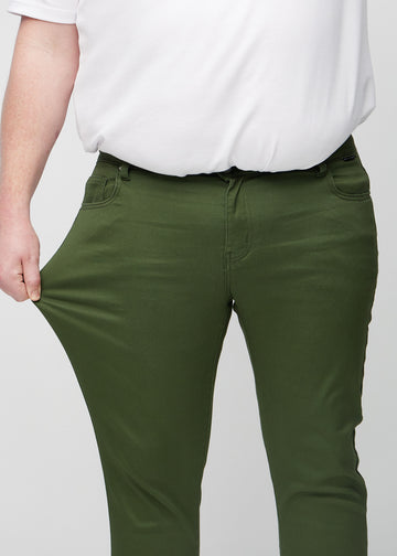 Plus-size model stretches the jeans at the thigh to show the fabric&