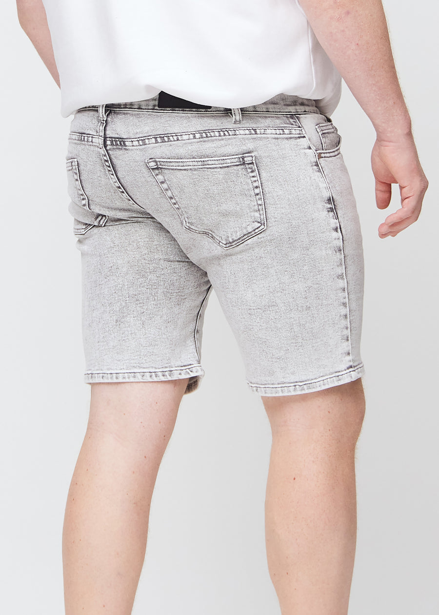 Light grey denim middle-regular shorts seen from the back close up on a plus-size model to show details.