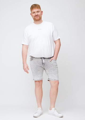 Full image of a plus-size model in light grey denim middle-slim shorts.