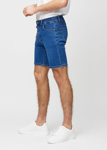 Dark denim middle-slim shorts seen from the side on a model.