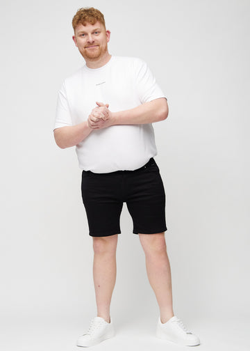 Full image of a plus-size model wearing black middle-slim shorts.