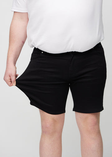 The plus-size model stretches the shorts at the thigh to show the stretch.