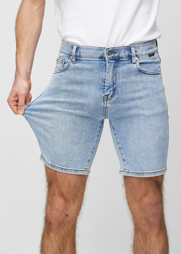 The model stretches the shorts at the thigh to show the stretch.
