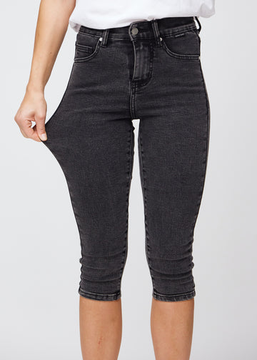 Model strækker caprisene ved låret for at vise stretch.