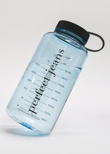 Gennemsigtig lyseblå vandflaske, der står på skrå med sort låg.
