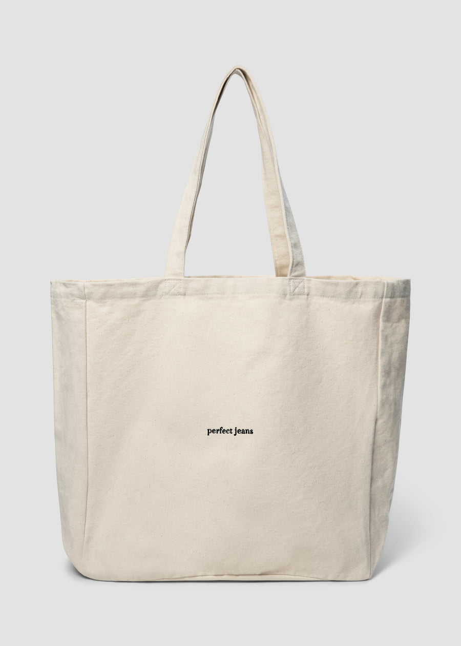 Beige tote bag by Perfect Jeans with a black logo on the front.