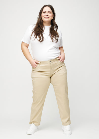 Plus-size model går ind i billedet, strækker i jeansene, viser dem frem ved at dreje rundt, og forlader derefter billedet.