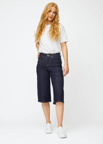 Model viser dyb mørkeblå denim capris til kvinder i farven Midnights med loose pasform i bevægelse.