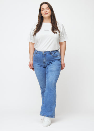 Plus-size model går ind i billedet, strækker i jeansene, viser dem frem ved at dreje rundt og forlader derefter billedet.